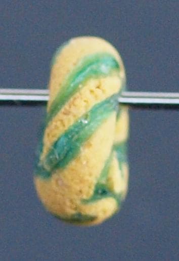 クリアな青緑に鮮やか黄で、回転する輪状モチーフを描くモザイク平玉　前後～6C頃の