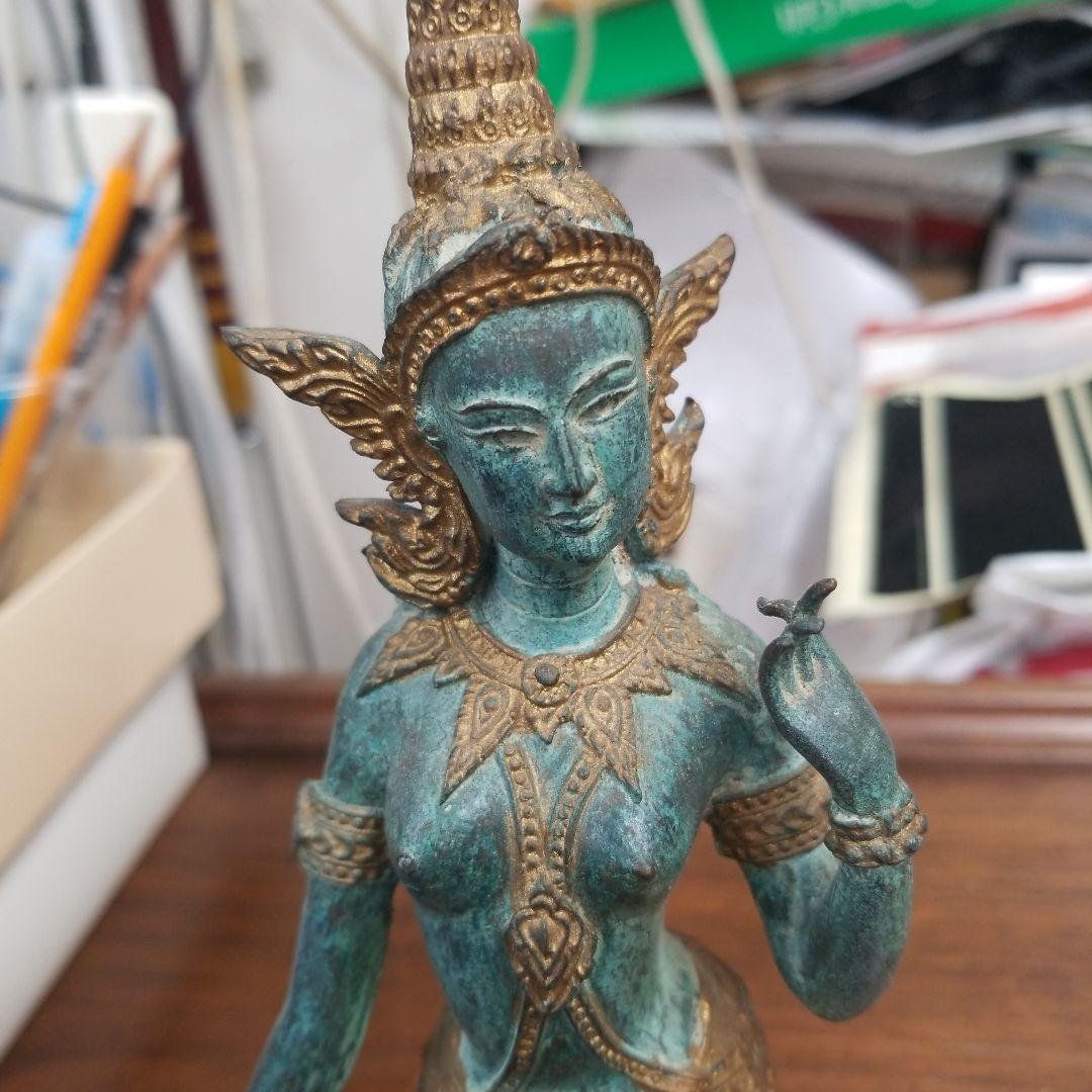 青銅色と金色のアジアの立像