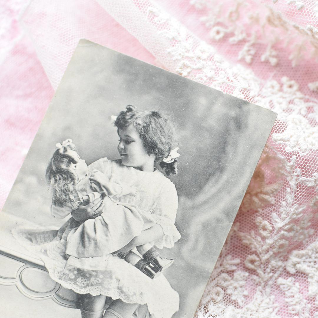 *アンティークポストカード　大きなお人形を抱く愛らしい少女