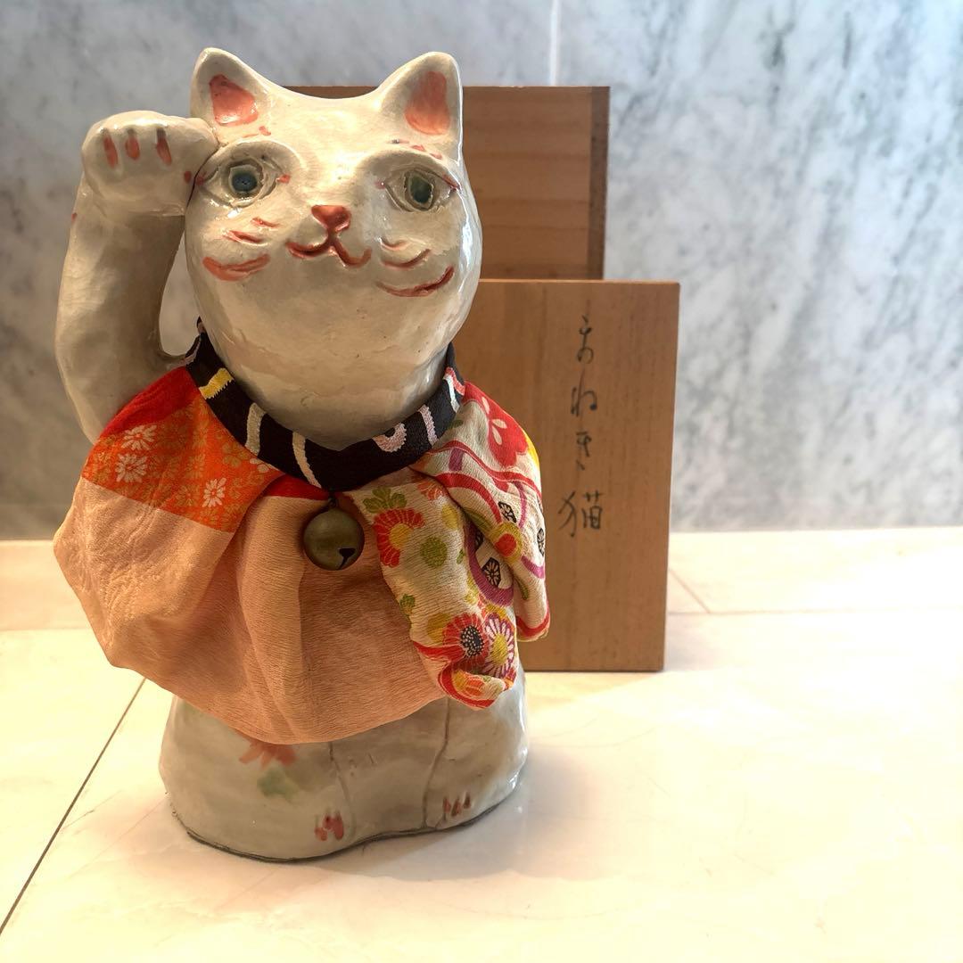 作家さんによる大きな瞳でにっこりと笑う着物の前掛けも美しい招き猫