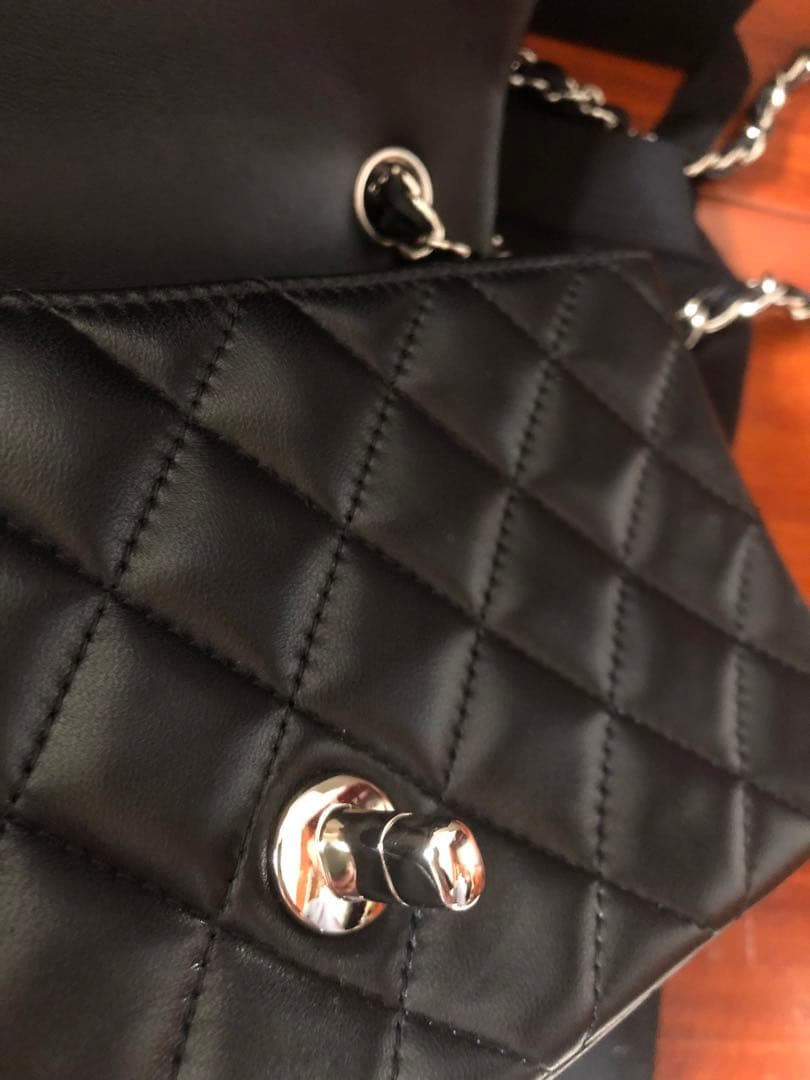 キルティングデザインのブラックレザーショルダーバッグ、チェーンストラップ付き。