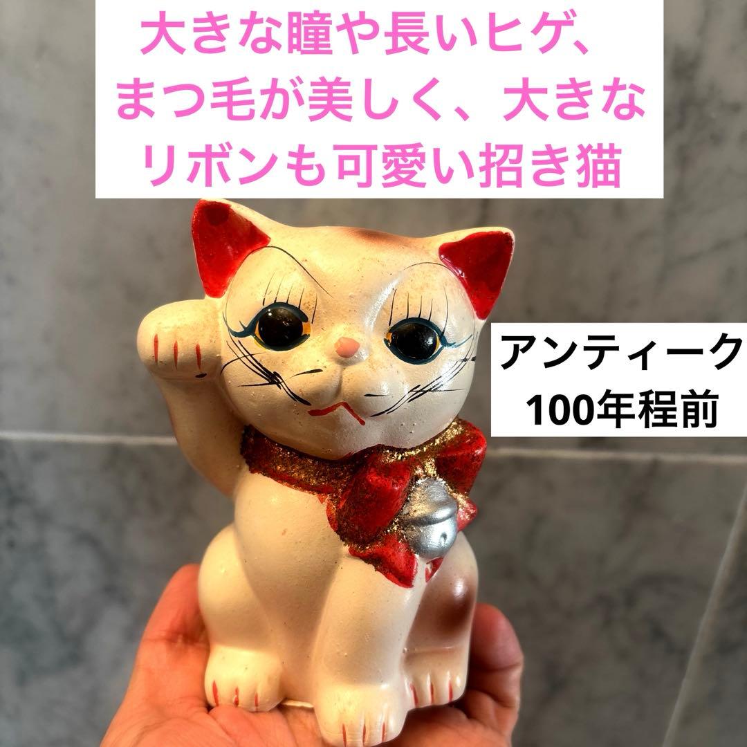 アンティーク大きな瞳や長いヒゲ、まつ毛が美しく、大きなリボンも可愛い招き猫