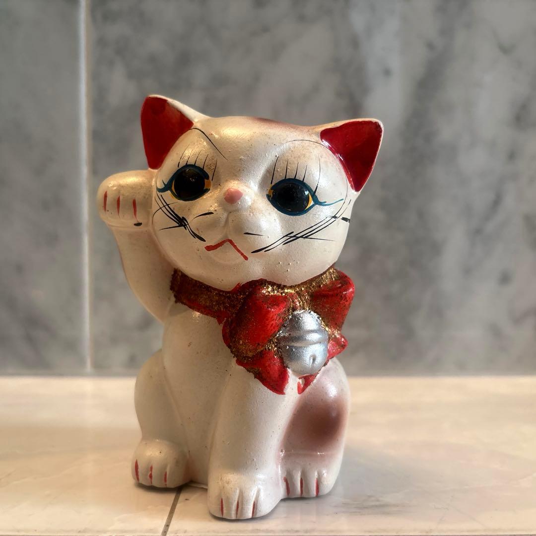 アンティーク大きな瞳や長いヒゲ、まつ毛が美しく、大きなリボンも可愛い招き猫