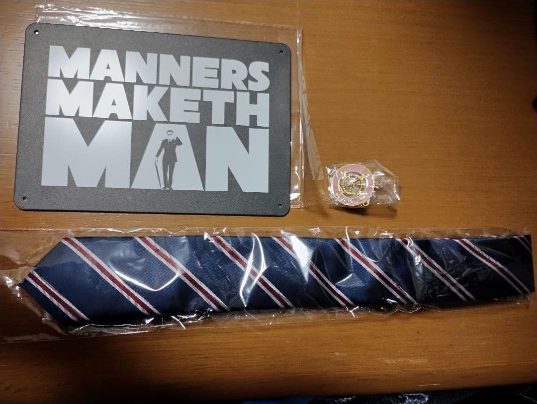 「キングスマン」の名台詞が記されたプレート、ネクタイ、メダルのレプリカのセット