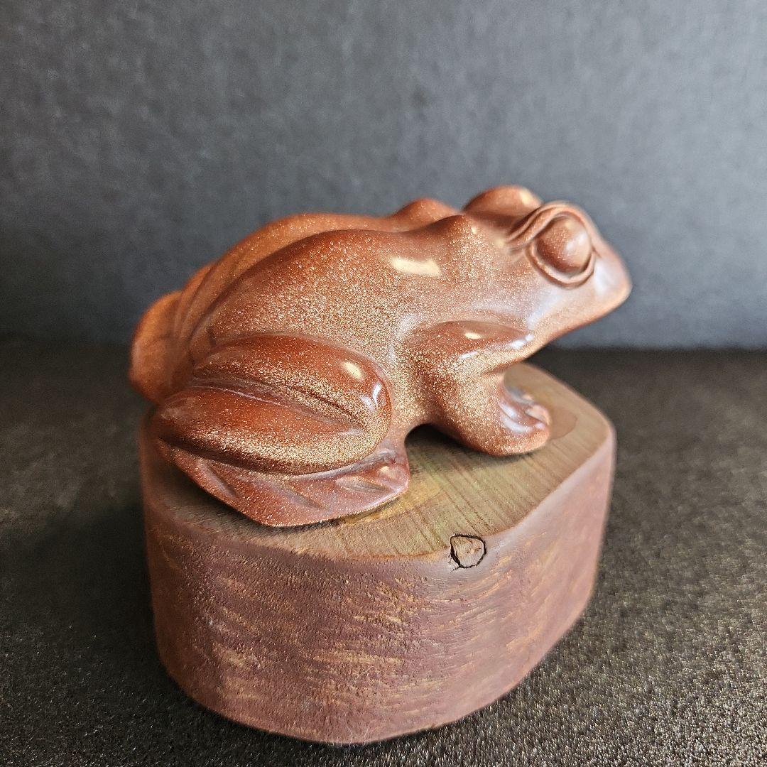 金色の光沢のあるブラウンカエルの石彫刻