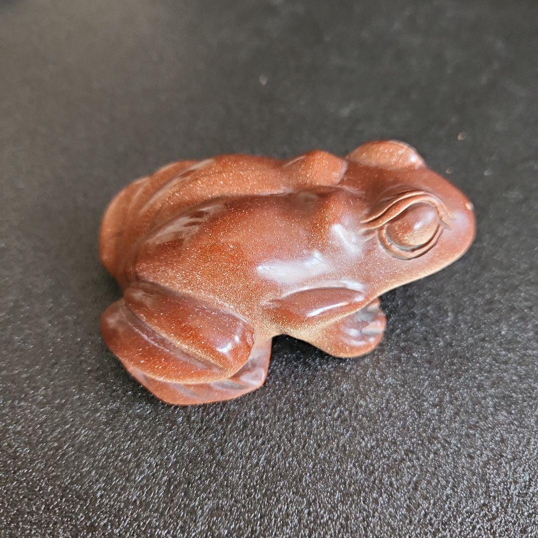 金色の光沢のあるブラウンカエルの石彫刻