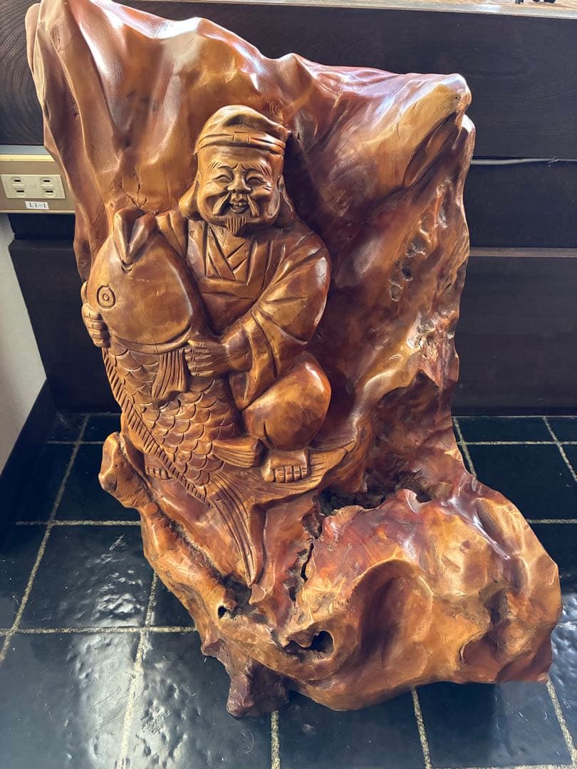 木彫りの装飾品 魚を持つ人物